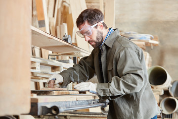 Schreiner schleift Holz am Bandschleifer