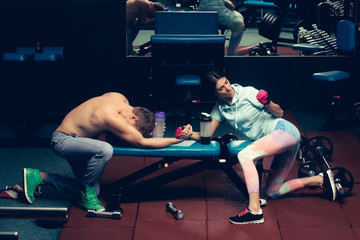arm wrestling muscular man and girl at gym - obrazy, fototapety, plakaty