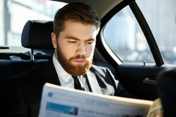 Concentrated business man reading newspaper