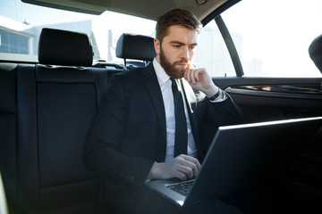 Serious business man using laptop computer