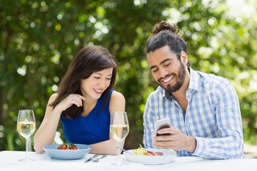 Couple using mobile phone in a restaurant