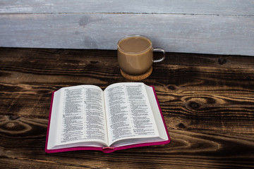 bible and coffee with milk on wooden background
