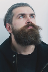 bearded serious brutal caucasian man in black jacket