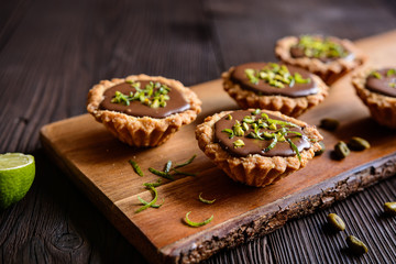 Tartlets with chocolate, pistachios and lime peel