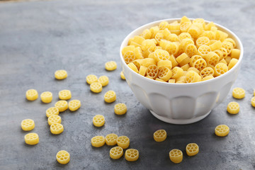 Heap of pasta in bowl on the grey wooden table
