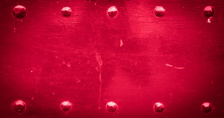 Red old metal background with rivets. Vintage abstract texture with shading borders.
