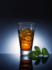 Glass of cola drink with ice and mint leaves. Cocktail aperitif juice