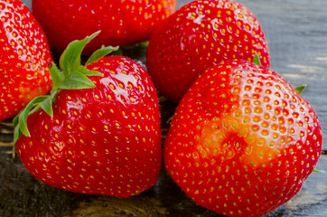 Strawberryes on wooden dark background.