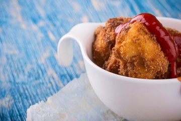 Detail of few pieces of fried cauliflower with ketchup
