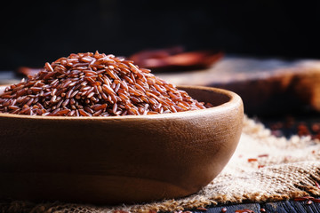Raw red rice, dark background, selective focus