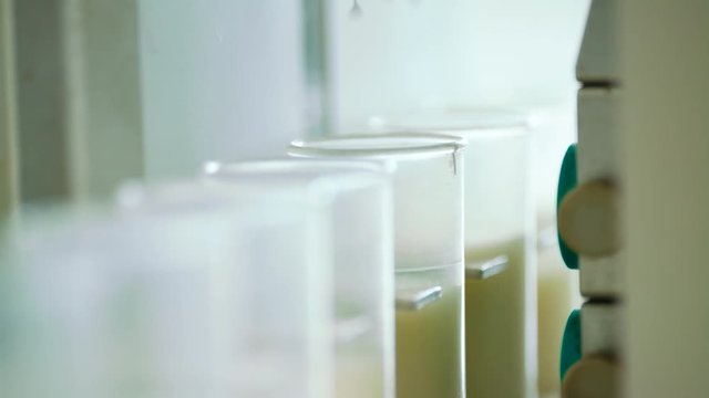 Milk analysis. Analysis of milk sample on laboratory equipment. Modern equipment. Scientist put glass with milk in laboratory equipment for research. Food quality test