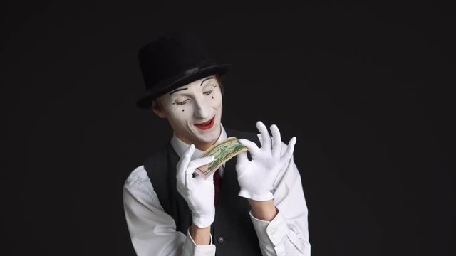 happy man mime holding a 50 dollar bill on black background
