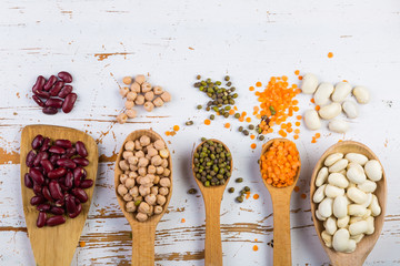 Selection of colorful beans on white wood background