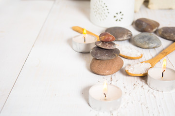 Pyramid of stones with sea salt on the spoons and candles
