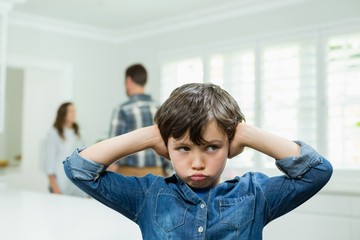 Boy covers his ears with his hands 