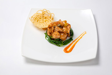 Fried chicken in sweet and sour sauce with french fries.
