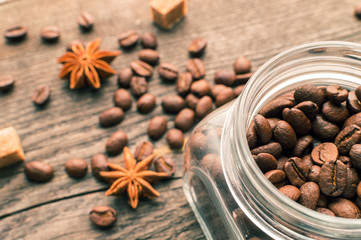 Coffee beans into glass jar table with sugar and anise