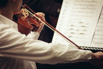 Violinist playing in orchestra close up