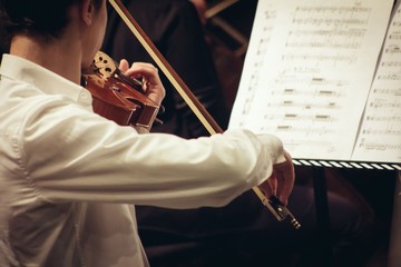 Violinist playing in orchestra close up