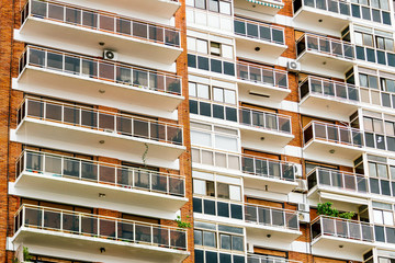 Fototapeta premium Apartment building with balconies and brick walls