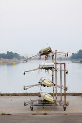 Boats on a stand on the shore of a rowing canal.