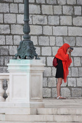 A woman is taking pictures in the rain.