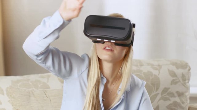 Beautiful Blonde Woman Uses Virtual Reality Headset at Her Living Room.  Shot on RED EPIC-W 8K Helium Cinema Camera.