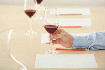 Sommelier estimating red wine in wineglass at tasting