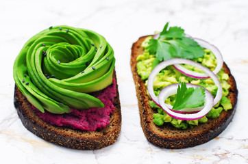 Avocado beet hummus and smashed avocado red onion parsley rye breakfast sandwiches