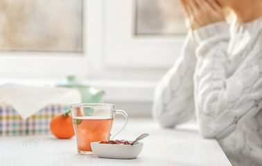 Cup of tea with raspberry jam on kitchen table