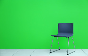 Grey modern chair on green wall background