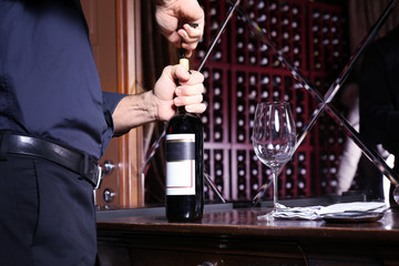 Man opening bottle of red wine