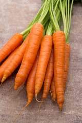 Fresh and sweet carrot on a grey wooden table.