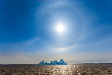 Sun Halo shining over the blue iceberg and ocean, North Greenland