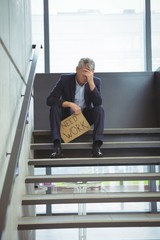 Depressed businessman sitting on stairs