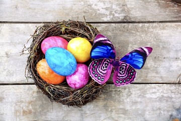 Osternest mit bunten Eiern und Schmetterling - Frohe Ostern