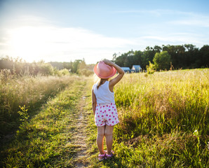 Beautiful little girl in the field at sunset. Nature, people