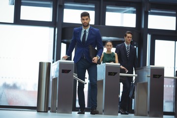 Businessman passing through turnstile gate - Powered by Adobe