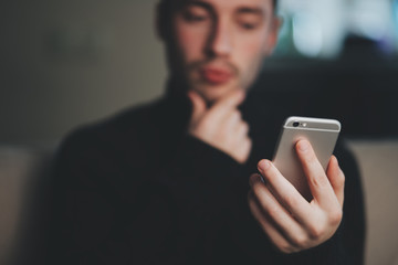 Man is thinking while searching on smart phone