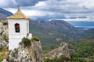 White bell tower. Landscape photo: View over the valleys of Puig Campana in the region of Alicante, Spain.