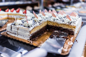 Slices of a layered chocolate and vanilla cake with cream topped with striped square