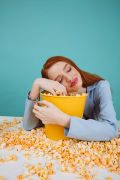 Vertical image of woman sleeping on basket with popcorn