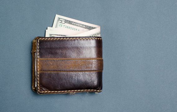 Dollar bills in brown leather wallet