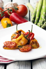 Roasted bell peppers with tomato sauce on the white rectangular plate. Rustic style.  