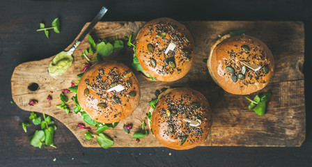 Healthy vegan burger with beetroot and quinoa patty, arugula, avocado sauce, wholegrain bun on...