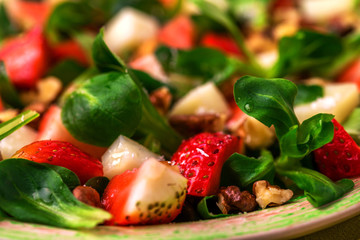 Salad with strawberry, spinach, walnuts and goat cheese