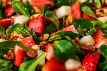 Salad with strawberry, spinach, walnuts and goat cheese