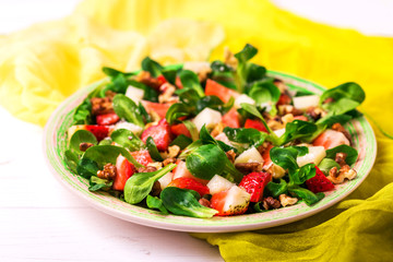 Salad with strawberry, spinach, walnuts and goat cheese