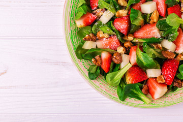 Salad with strawberry, spinach, walnuts and goat cheese