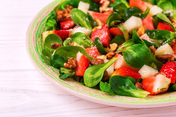 Salad with strawberry, spinach, walnuts and goat cheese